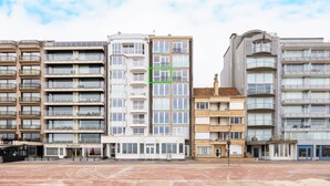 A row of multi-story residential buildings with balconies, a paved ground, and a clear sky. - Apartment by Belgian Coast With Beach Views (Koksijde)