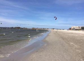 Una playa con arena, un mar tranquilo y cielo despejado.