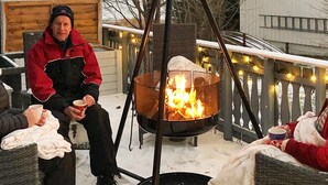 A group of people seated around a fire pit on a snow-covered deck. - 4 Star Holiday Home in Vikholmen (Nesna)