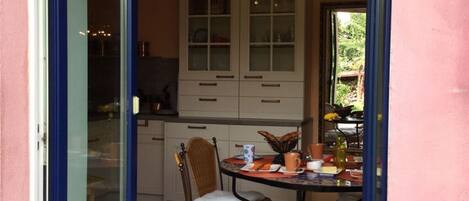 A dining area with a round table, chairs, and a cabinet in the background.