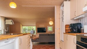 Une cuisine compacte avec des meubles en bois, un four encastré et une machine à café.