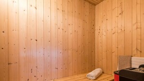 A sauna room with wooden walls and benches. - 6 Person Holiday Home in Norre Nebel (Norre Nebel)