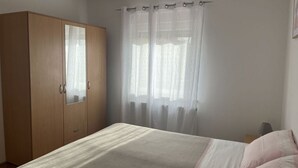A bedroom with a bed, a wardrobe, and a window with sheer curtains. - Medulin Burle A4+1 (Medulin)