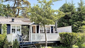 A house with a porch, a staircase leading to a deck, and a small garden area. - 4 Star Holiday Home in Aplared (Aplared)