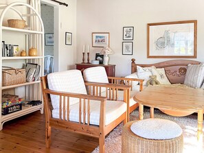 A cozy room with a wooden bed, a round table, a wicker chair, and a bookshelf. - 4 Star Holiday Home in Aplared (Aplared)