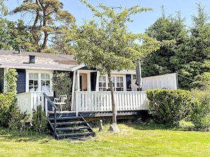 A house with a porch, a small deck, and a staircase leading to the deck. - 4 Star Holiday Home in Aplared (Aplared)