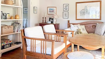 Una habitación acogedora con una cama de madera, una mesa redonda y una estantería llena de libros y objetos decorativos.