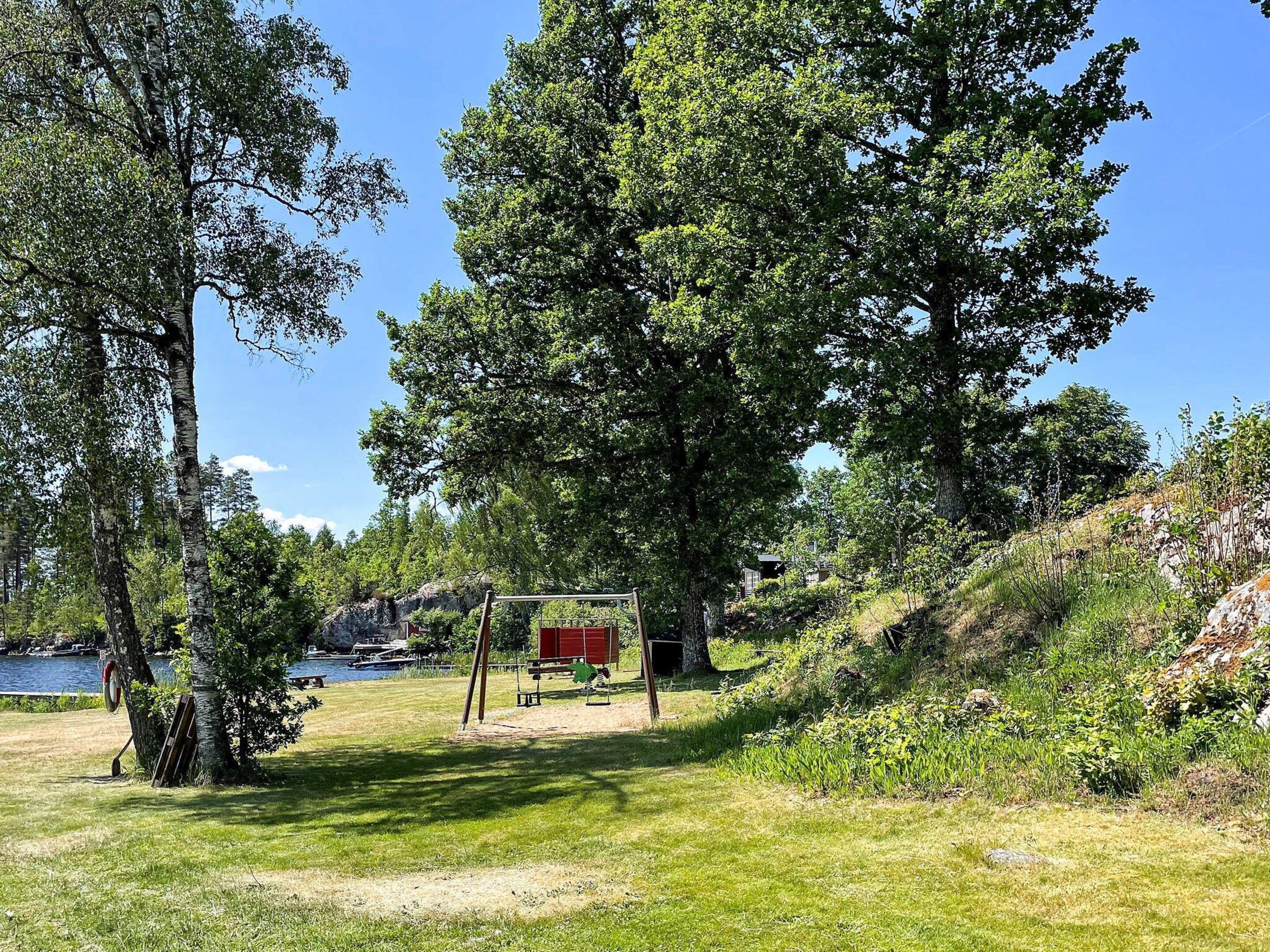 A natural landscape with a lake, trees, and a red structure.