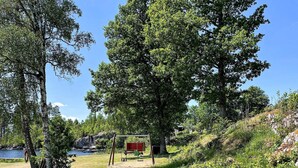 A natural landscape with a lake, trees, and a red structure. - 4 Star Holiday Home in Aplared (Aplared)