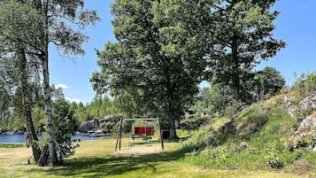 A natural landscape with a lake, trees, and a red structure.