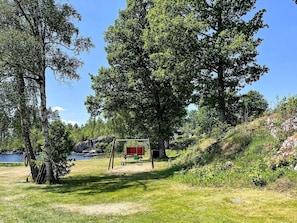 A natural landscape with a lake, trees, and a red structure. - 4 Star Holiday Home in Aplared (Aplared)