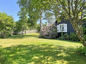 A house with a well-maintained lawn and flowering bushes. - 4 Star Holiday Home in Aplared (Aplared)