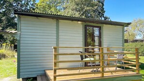 A small, single-story cabin with a wooden deck and a table with chairs. - 6 Person Holiday Home in Bergkvara (Bergkvara)