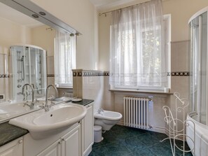 Un baño con lavabo, espejo, inodoro y ducha.