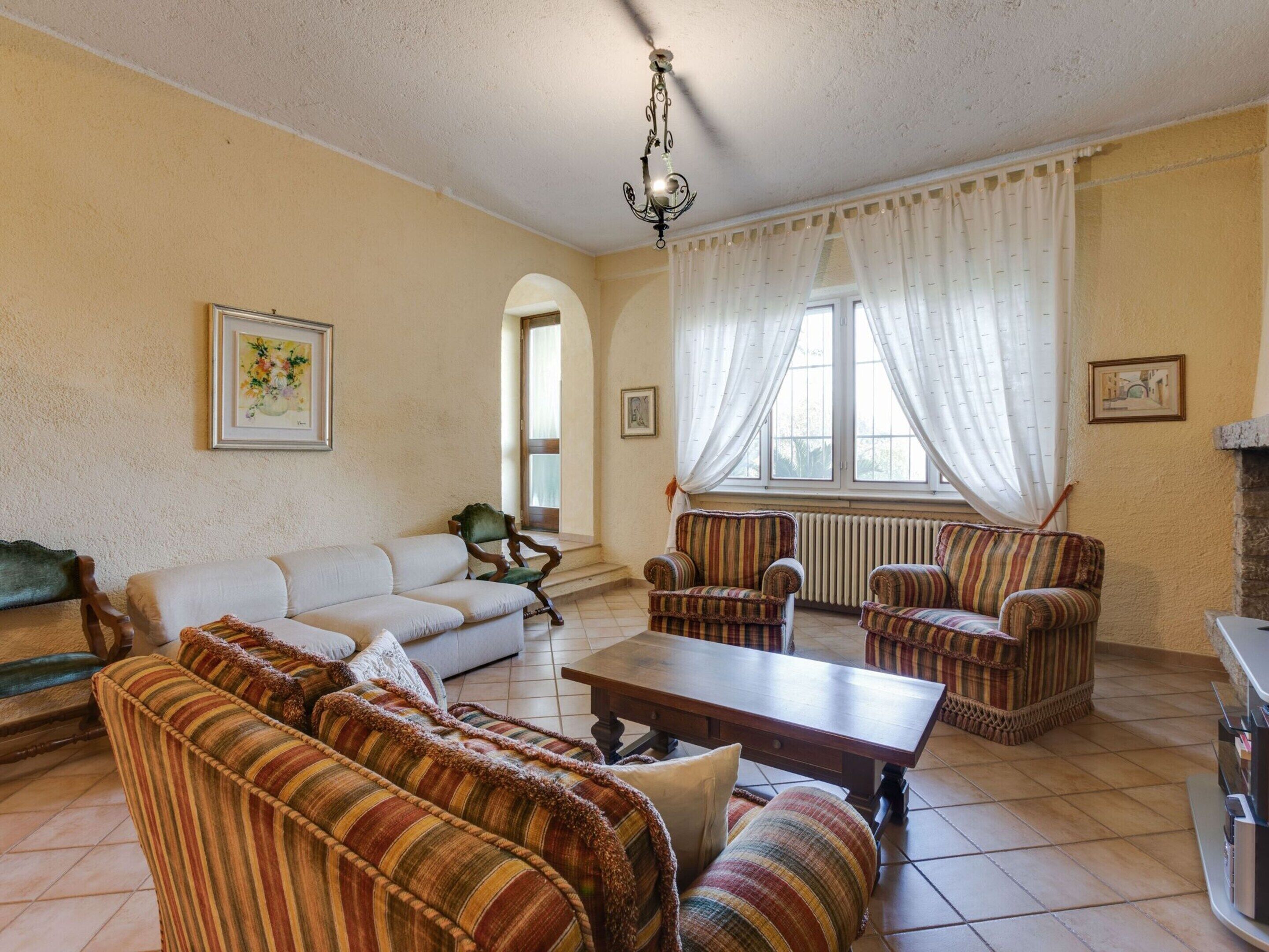 Ein Wohnzimmer mit einer Couch, Sesseln, einem Couchtisch und einem Kamin.