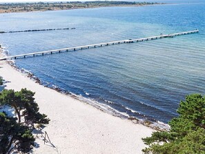 A beach with a long pier extending into the water, surrounded by sand and sparse vegetation. - 4 Person Holiday Home in Solvesborg (Sölvesborg)