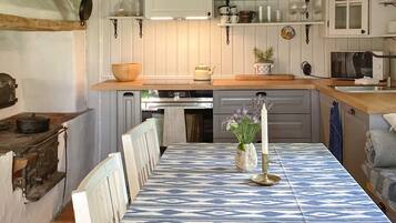 A kitchen with a central island, white cabinetry, and a patterned tablecloth.