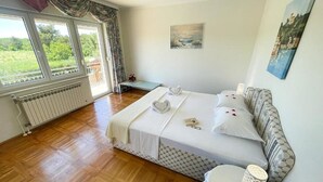 A bedroom with a large bed, a bedside table, a radiator, and a window with curtains. - Apartment in Croatia Near Adriatic Coast (Crikvenica)