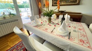 A dining table set for six with white tablecloths and napkins, a vase with flowers, and a painting on the wall. - Apartment in Croatia Near Adriatic Coast (Crikvenica)