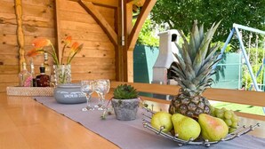A wooden table with a fruit bowl containing apples and a pineapple, a small succulent plant, and a bottle labeled "SMOKER LOU". - Apartment in Croatia Near Adriatic Coast (Crikvenica)