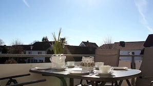A table set outdoors with a clear view of houses in the background. - "isabel" in the House to the cog (Zingst)