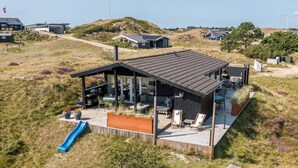 A modern house with a covered patio, a slide, and a view of the surrounding landscape. - 4 Person Holiday Home in Fano (Fano)