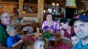 A family dining at a rustic wooden restaurant with a fireplace and wooden beams.