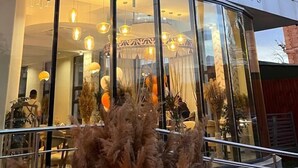 Un bâtiment moderne doté d’une façade en verre et d’une enseigne indiquant « espace de création ».
