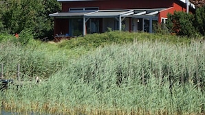 A modern house with a flat roof, large windows, and a covered porch area. - Schleipanorama Modern Retreat (Brodersby)