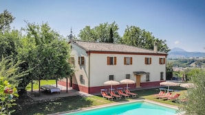 A two-story house with a swimming pool, outdoor seating, and a view of the countryside. - Belvilla by OYO Villa Sapori (Pergola)