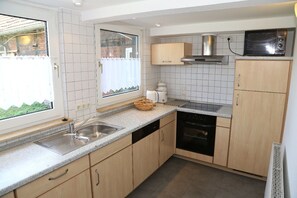 Kjøleskap, mikrobølgeovn, oppvaskmaskin og høy barnestol