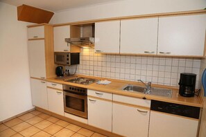 Kjøleskap, mikrobølgeovn, oppvaskmaskin og høy barnestol