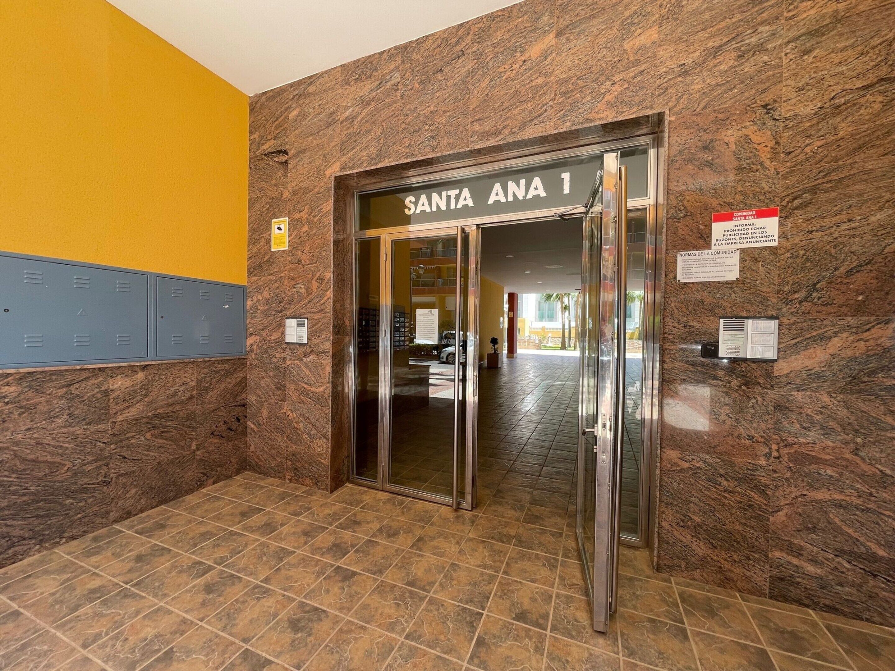 Entrada de hotel con pared de mármol y un letrero que dice "SANTA ANA 1".