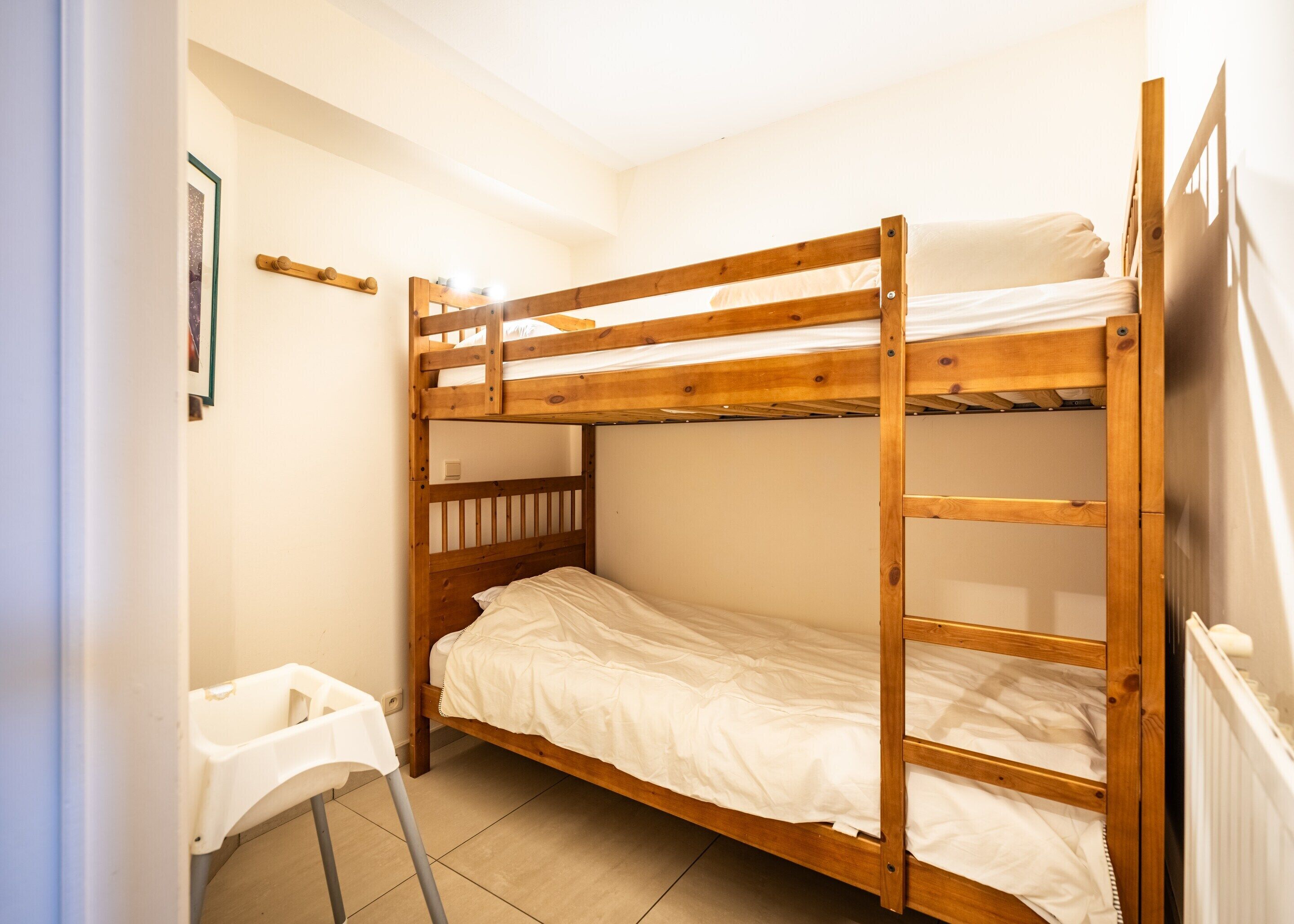 A bunk bed room with a small table and a ladder.