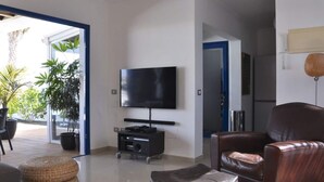 A modern living room with a flat-screen TV, leather sofa, and ottomans. - Villa Bella Vista Blu (Yaiza)