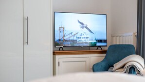 Een televisie aan de muur met daarop een zeemeeuw die boven een schip vliegt.