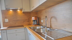 A kitchen with wooden cabinets, a stainless steel sink, and a coffee maker. - Villa in Durbuy With Ardennes Views (Durbuy)