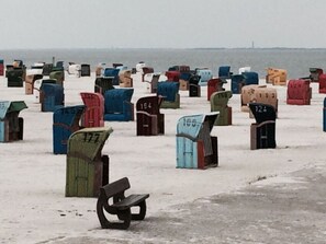 A row of numbered mailboxes in various colors, with a bench in the foreground. - Holiday Home Nispel Comfortable Vacation Home (Dornum)