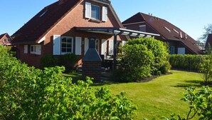 A two-story house with a brick facade, a pitched roof, and a covered porch. - Holiday Home Nispel Comfortable Vacation Home (Dornum)