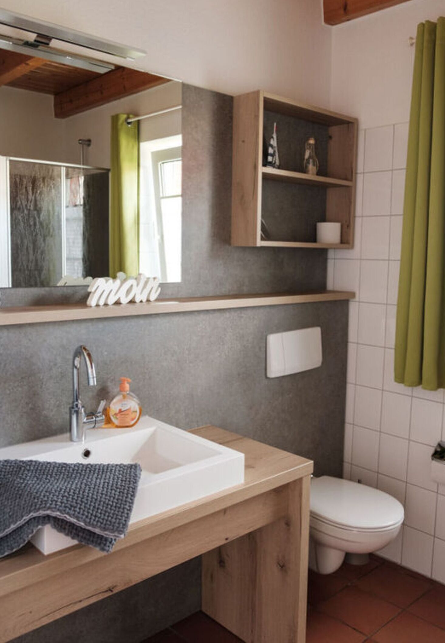A bathroom with a white sink, mirror, and a shelf above the sink.