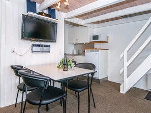 A compact kitchen with a microwave, a small refrigerator, and a dining area with a table and chairs. - 4 Person Holiday Park Home in Hemmet (Hemmet)