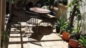 A patio area with a pergola, tiled flooring, and potted plants. - Location Villa Juin-juillet (La Possession)