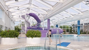 Una piscina interior con tobogán y fuente.