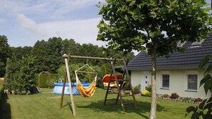 Una casa amb un tobogan i una piscina blava al pati darrere.
