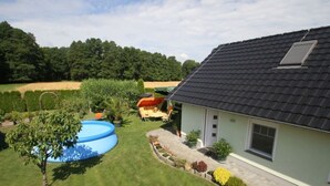 Una casa amb piscina, jardí i zona de pati.