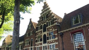 Un bâtiment traditionnel en briques, doté d’un toit à pignon et de nombreuses fenêtres.