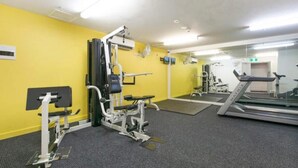 A gym with exercise equipment, a treadmill, and a mirrored wall. - Hotel Style Room in the heart of Darwin  (Darwin City)