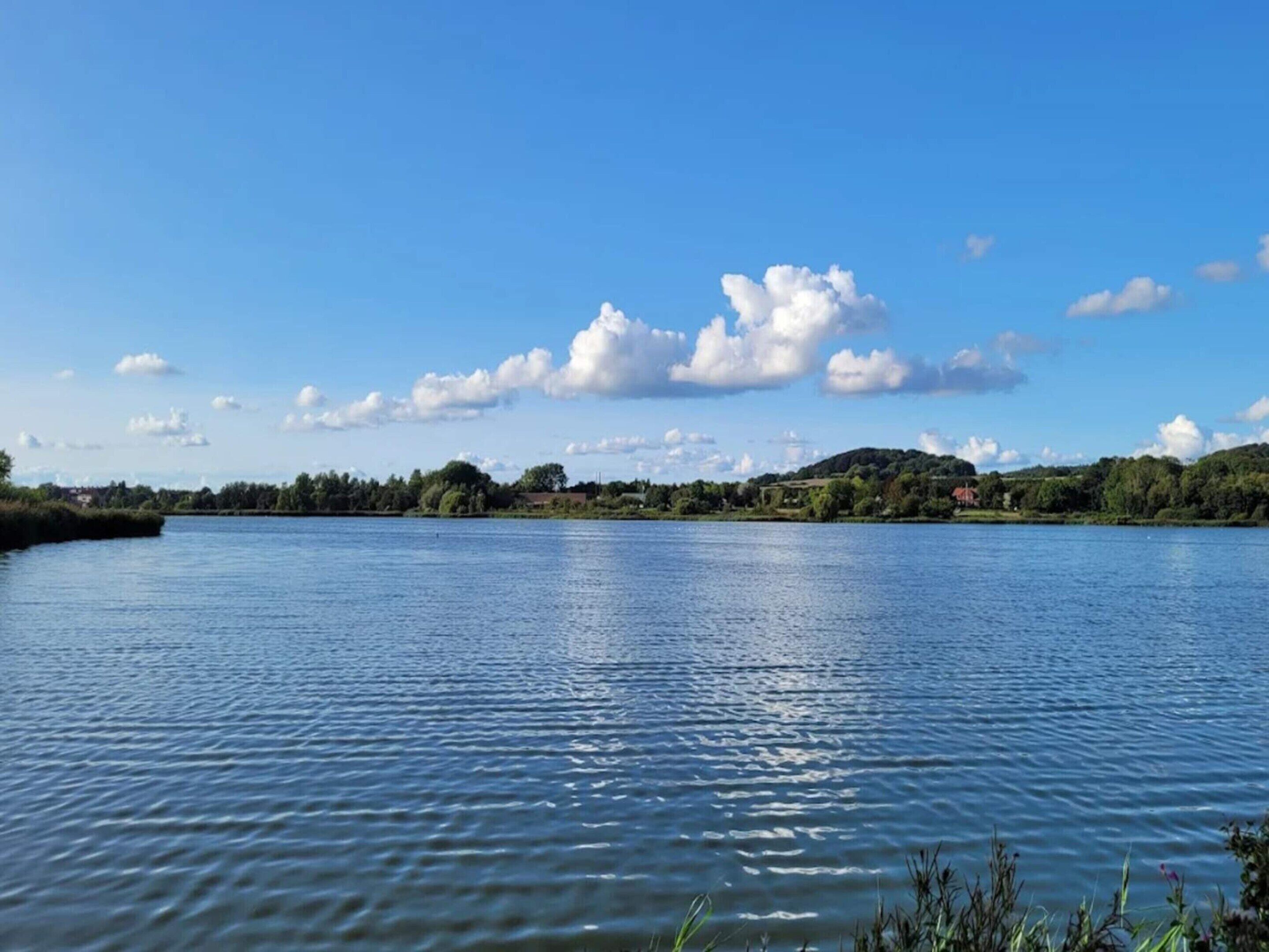 Een rustig meer met een heldere lucht en enkele wolken.