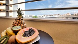 A balcony with a railing, a pineapple, a papaya, a banana, and a kiwi. - Belvilla by OYO Apartamento Sol y Paraaso I (Adeje)