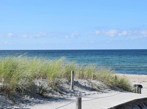 A beach with sand, grass, and the ocean. - Holiday Home Wiedblick (Rerik)
